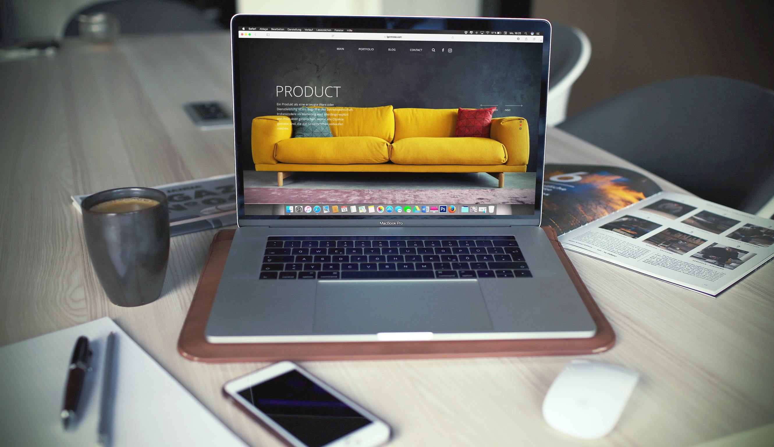 MackBook Pro with sofa on the screen and a cup of coffee on the table
