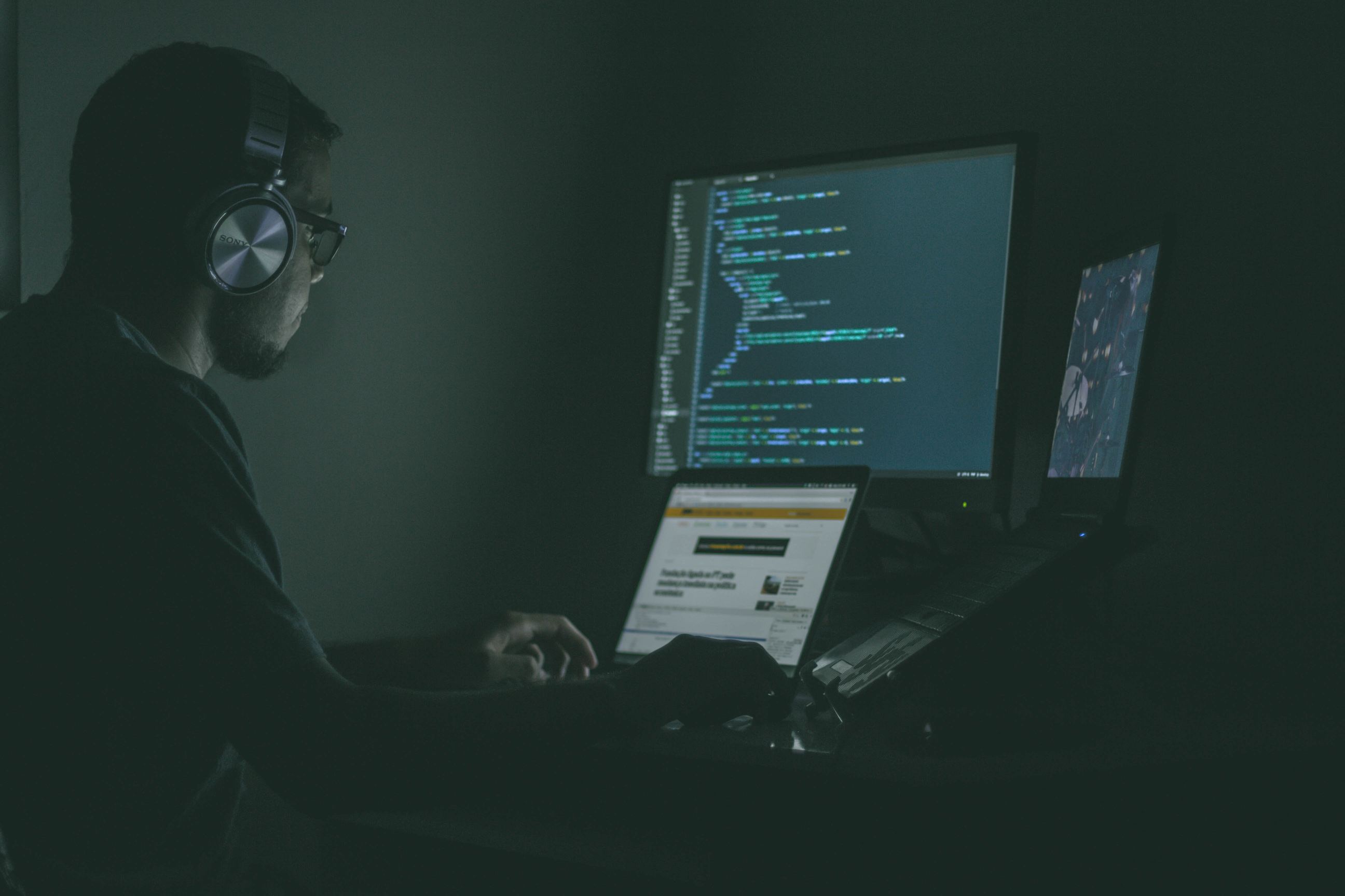 Man listening to music in front of the computers and coding